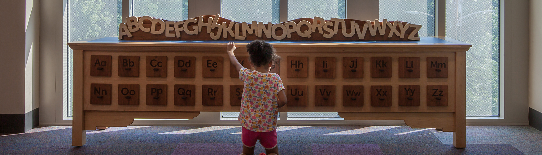 girl playing with a kid's card catalog